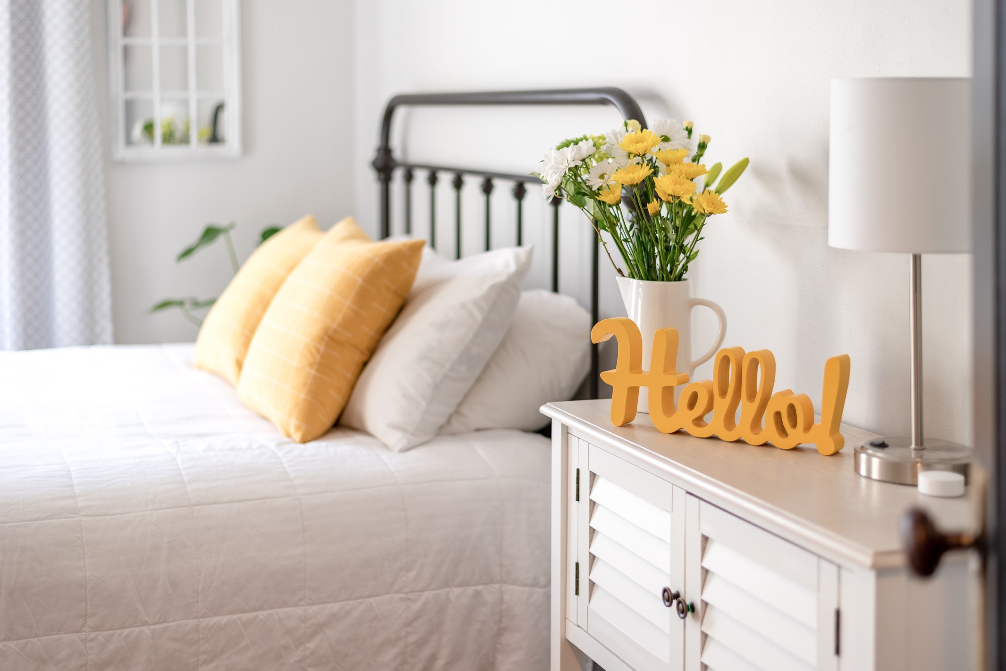 cheerful-hello-sign-and-fresh-flowers-in-a-clean-and-bright-bedroom.jpg